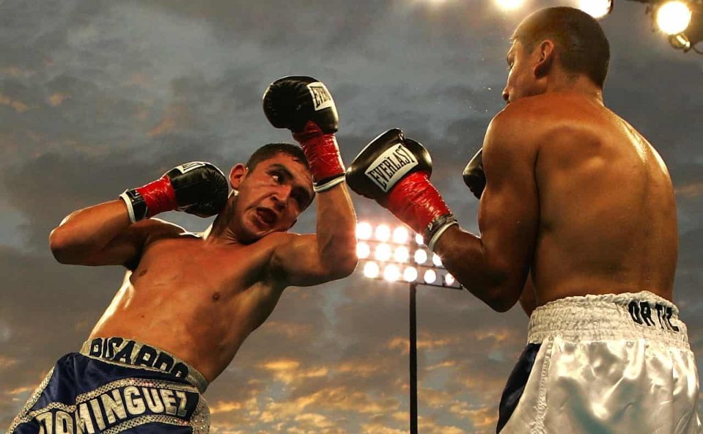 Boxe para adultos: 5 benefícios comprovados para quem quer começar 1 boxe para adulto - praticante desfere uppercut durante luta